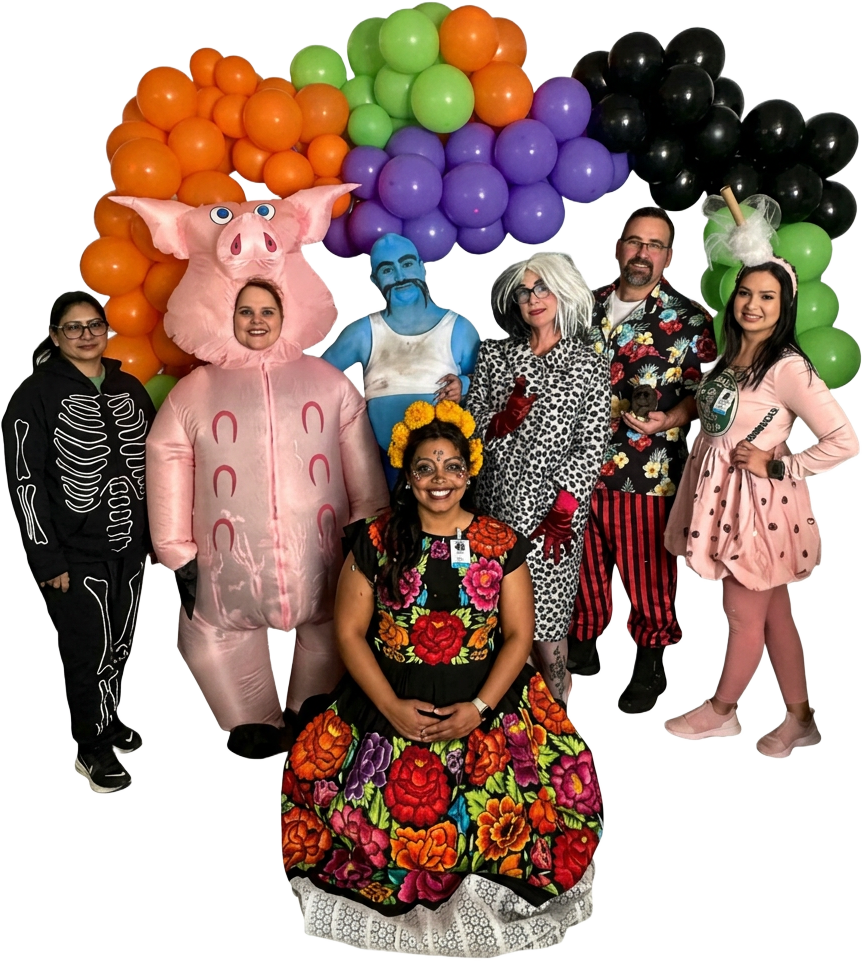 Last year's Fresno Hospice team in costume under a Halloween balloon arch